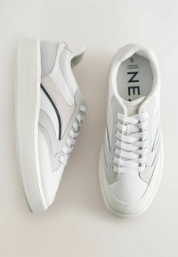 Sneakers bianchi realizzati con una combinazione di materiali in pelle e camoscio, con una forma della punta arrotondata, accenti testurizzati e lacci piatti con dettagli blu.