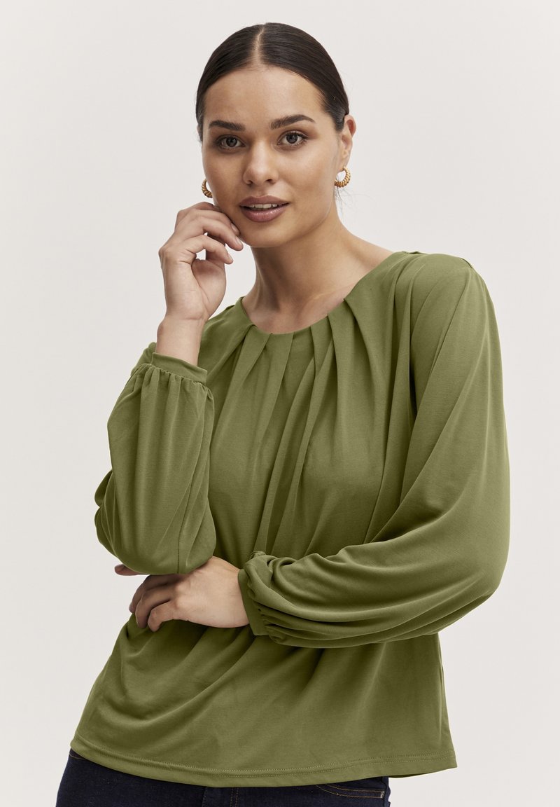 Grüne Bluse mit langen Ärmeln, gerafftem Halsausschnitt und plissierten Details, mit puffärmel und einem weichen, fließenden Stoff.