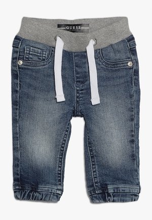 Denim joggerbukser med grå ribstrikket talje, snørelukning, sidelommer og manchetter i en mørk vask med falmede detaljer.