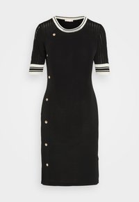 Svart knälång klänning med korta ärmar, vita och svarta randiga detaljer vid ärmsluten och halsringningen, knapplanet för detalj längs vänster sida.