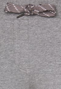 Graue Stoffhosen mit einem braun-weißen gemusterten Kordelzug, der an der Taille zu einer Schleife gebunden ist.