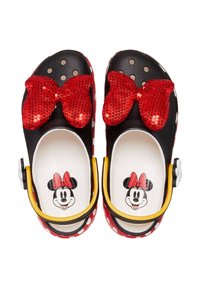 Schwarze und rote Clogs mit einer großen roten mit Pailletten besetzten Schleife, weißen Punkten und einem bedruckten Minnie-Maus-Gesicht innen. Gelbe Akzente an den Seiten.
