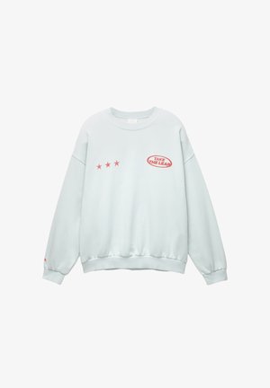 Světle zelená mikina s dlouhými rukávy, vroubkovanými manžetami a lemem. Na přední straně se nachází červený nápis "SKOČTE DO TOHO" a tři červené hvězdy.