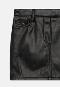 Svart skinn mini skjørt med en jevn tekstur, frontlommer og en sølvfarge aksent nær midjen. Har en skreddersydd design og rene linjer.