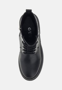 Stivaletto nero alla caviglia con tomaia in pelle liscia, punta tonda, chiusura frontale con lacci, dettagli in argento e linguetta posteriore. Pannello laterale testurizzato.