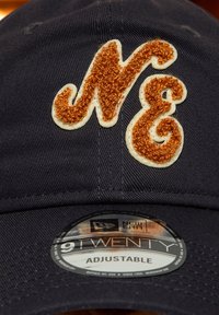 Tengerészsapka texturált, hímzett világosbarna "NE" logóval. Állítható pánt hátul, kör alakú "New Era" címkével a karimán.