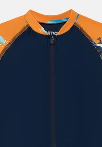 Camisa de mergulho azul-marinho com detalhes laranja, apresentando um fecho frontal e desenhos aquáticos impressos em tons de azul e verde ao longo dos ombros.