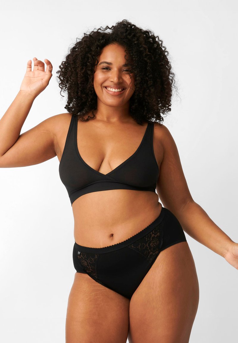Brasile wireless nera con scollatura profonda e mutandine nere coordinate con dettagli in pizzo e bordi ondulati. Tessuto morbido e elasticizzato.