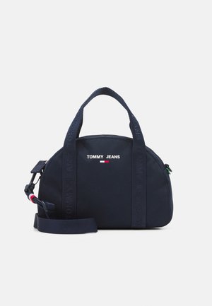 Sac à main compact bleu marine Tommy Jeans avec deux poignées supérieures, bandoulière amovible et logo imprimé au centre avant.