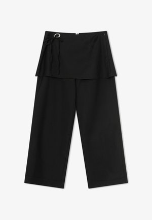 Čierne široké nohavice s pripojenou vrstvou sukne na zavinutie a opaskom s D-krúžkom na ľavej strane v páse.