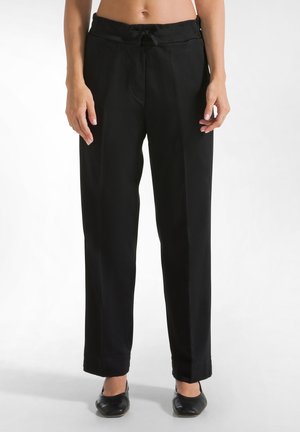 Zwarte, wijde broek met een strikband in de taille. Gemaakt van lichte stof met een gladde textuur. Heeft een getailleerde pasvorm en opgerolde boorden.