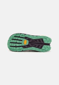 Vibram yttersåle med et svart og grønt fargeskjema. Har dype spor for grep, teksturert overflate og distinkte gule merkevaredetaljer.