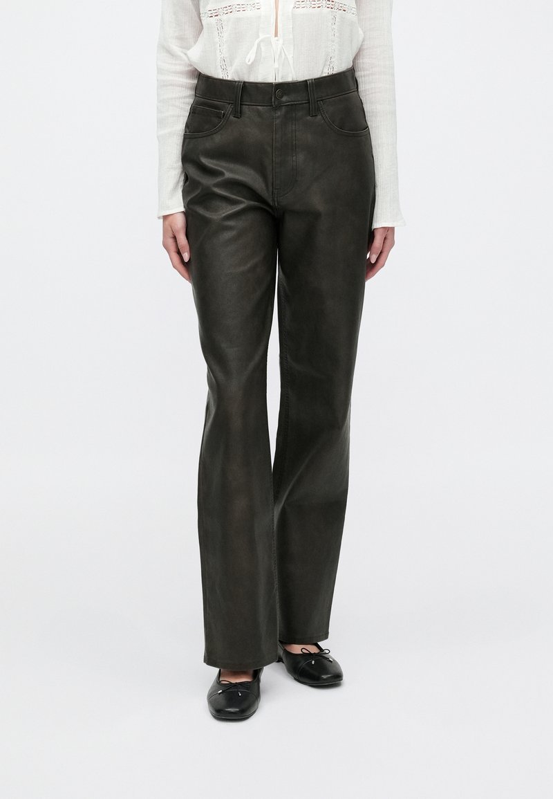 Dark green leather flared pants with a mid-rise waist, five-pocket design, and subtle sheen; paired with black flat shoes.