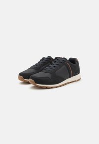 Black athletic shoes made of suede and mesh, featuring a rubber sole, rounded toe, and brown accent details on the side and heel.