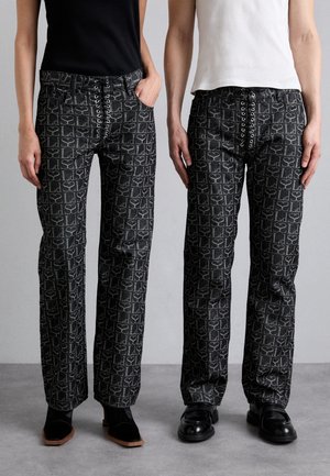 Schwarze gemusterte Hosen mit geometrischem Design, mit einer Schnürung an der Vorderseite und geradem Bein. Hergestellt aus einem strukturierten Stoff.