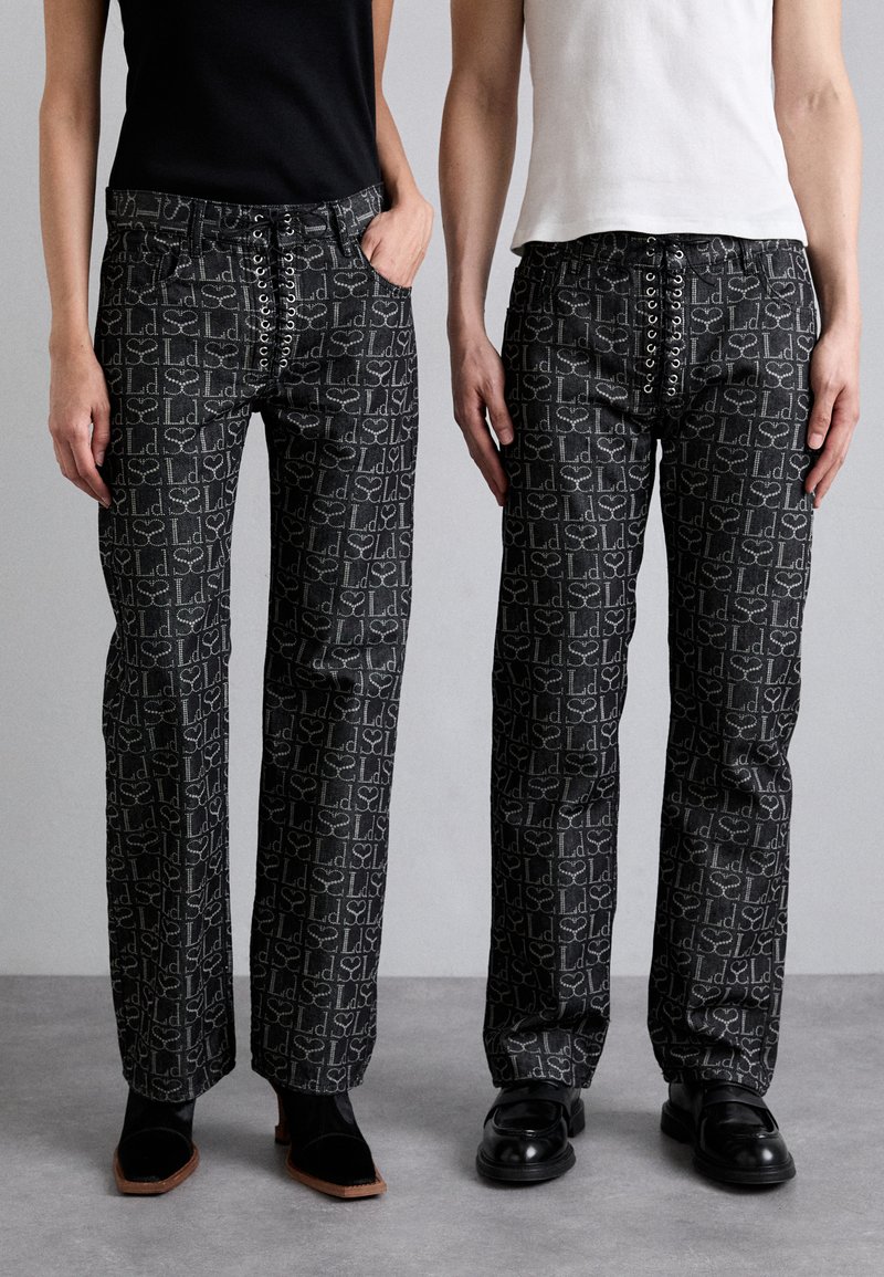 Pantalons noirs à motif géométrique, avec un devant à lacets et une coupe droite. Fabriqués dans un tissu texturé.