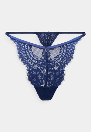 Navy blue lace thong with intricate floral patterns, scalloped edges, and thin straps, featuring a small accent detail at the center.