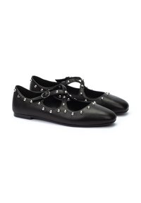 Zapatos de ballet de cuero negro con punta redondeada, tiras al estilo Mary Jane y tachuelas decorativas plateadas a lo largo de los lados. Suela plana.