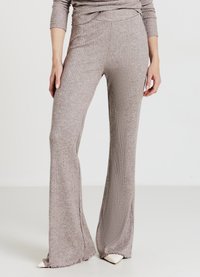 Pantaloni a coste color marrone chiaro a zampa, realizzati in un materiale morbido, con vita aderente e dettagli di orlo sfrangiato.