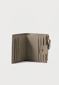 Carteira de couro greige com múltiplos compartimentos para cartões e um compartimento com fecho zip. Apresenta ferragens em tom dourado e fecho de botão. Textura suave.
