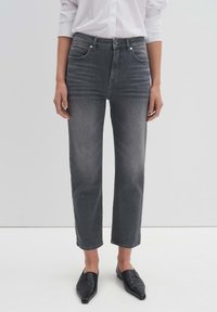 Jeans de talle alto grises con corte recto, diseño de cinco bolsillos y un leve desgaste. Combinados con zapatos negros tipo slip-on.