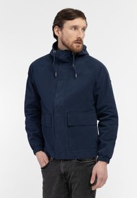 Navy blue hooded jacket made of smooth fabric, featuring two front patch pockets and elastic cuffs for a comfortable fit.