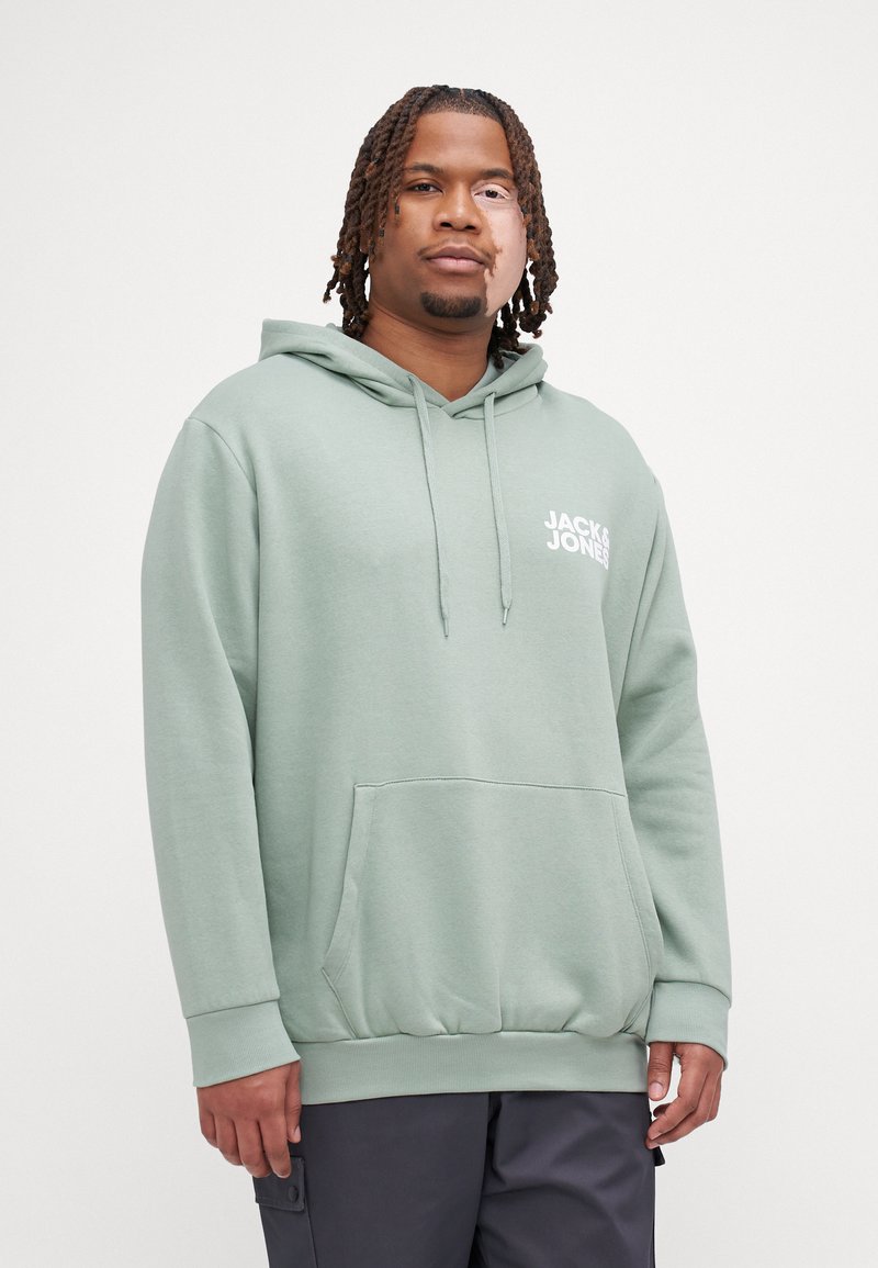 Mintgroene hoodie met een trekkoord, zijzak, ribgebreide onderrand en manchetten, met een witte logo-opdruk op de borst. De stof lijkt zacht en textuur te hebben.