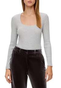 Light gray ribbed long-sleeve bodysuit with a square neckline, paired with black velvet high-waisted trousers.