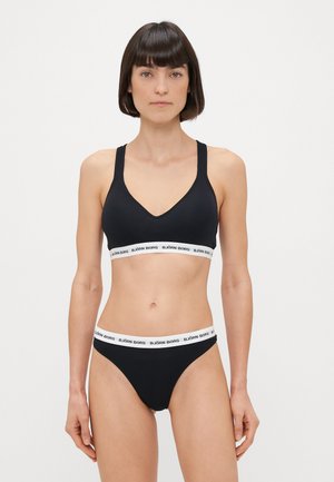 Soutien-gorge de sport noir et culottes assorties avec une ceinture élastique blanche arborant "BJÖRN BORG" en noir. Tissu lisse et design ajusté.