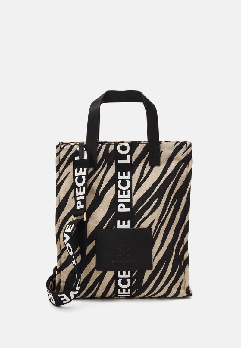 Sac fourre-tout en toile avec un imprimé zèbre beige et noir. Il comporte des poignées noires, une sangle ajustable avec le texte "PIECE LOVE", et un patch logo noir.