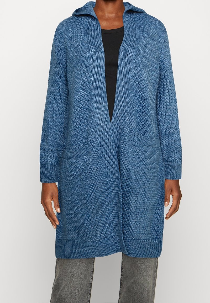 Blå stickad kofta med huva, med ett strukturerat mönster, öppen front och två framfickor. Långa ärmar och ribbade muddar.