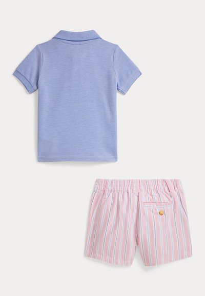 Μπλε πόλο μπλούζα με κοντά μανίκια, υφασμάτινη υφή. Κάτω, ροζ ριγέ σορτς με πίσω τσέπη και λεπτομέρεια πορτοκαλί κουμπιού.