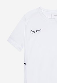 Valkoinen Nike lyhythihainen urheilupaita, jossa vasemmassa rinnassa musta Nike-swoosh-logo ja verkkokankaiset sivupaneelit mustilla reunoilla.