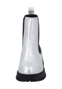 Botín Chelsea metálico plateado con un lado elástico negro. Presenta una pestaña en el talón y una suela de goma negra texturizada.