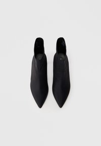 Czarne botki za kostkę z wydłużonym noskiem, wykonane z gładkiego materiału. Charakteryzują się wysokim stanem i minimalistycznymi akcentami.