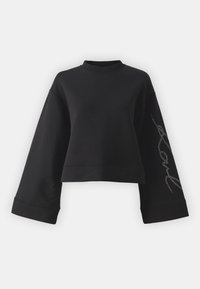 Zwarte verkorte sweatshirt van een zachte stof. Heeft brede mouwen en een hoge hals met een zilveren rhinestone versiering op één mouw.
