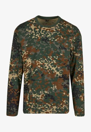 Roheline, pruun ja beež kamuflaažipritsaka pikade varrukatega T-särk, ümmarguse kaelusega. Omab segatud mustrit ebaregulaarsest täppidest ja tekstuuridest.