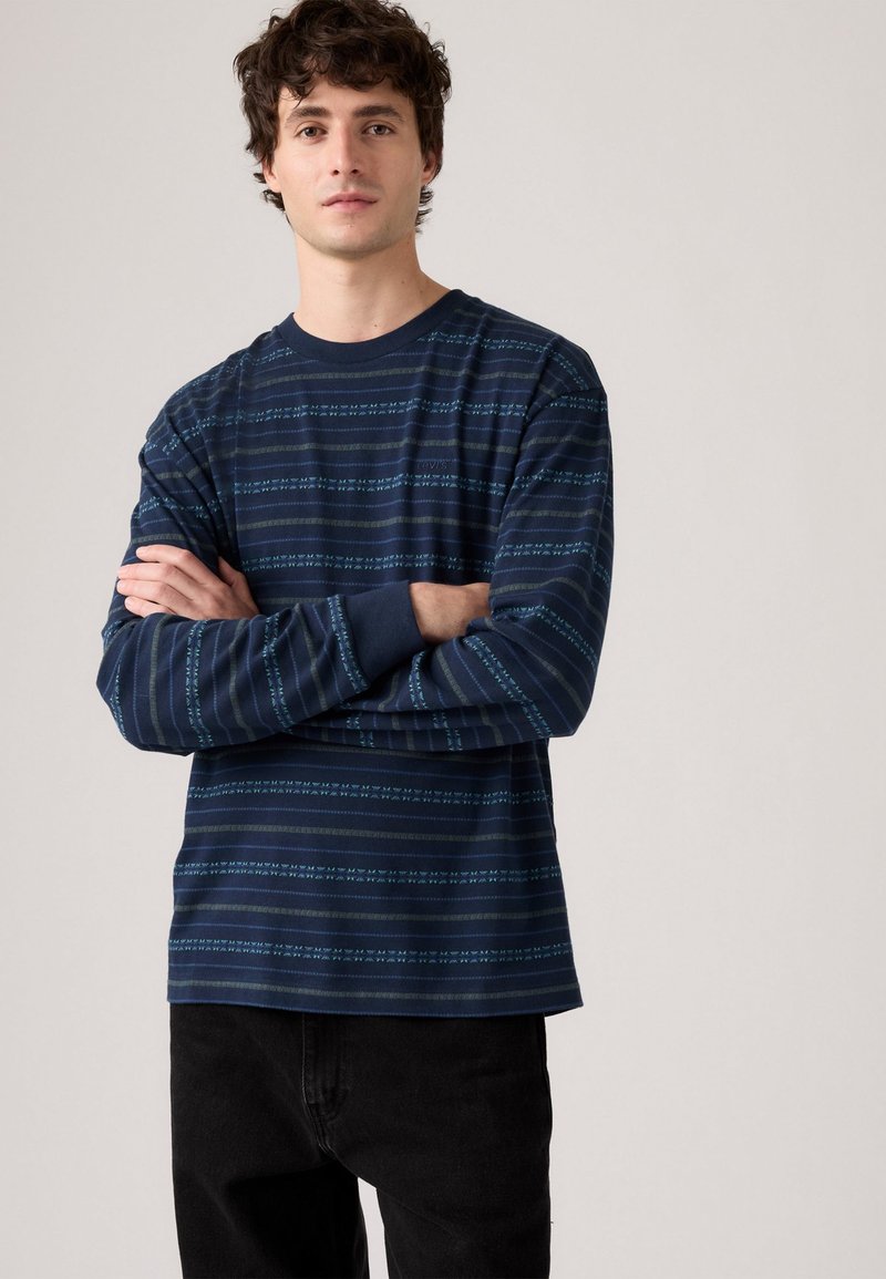 Maglietta a maniche lunghe navy con righe orizzontali in blu chiaro e accenti sottili, realizzata in tessuto morbido, con colletto rotondo.