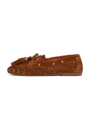 Mocassin en daim marron avec des motifs géométriques découpés au laser, des pampilles et des perles décoratives sur le dessus, présenté de profil sur un fond blanc.