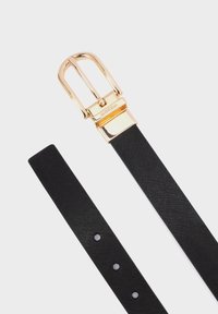 Zwarte textuur riem met een gouden metalen gesp. De gesp heeft een klassieke pinontwerp en de band heeft vijf gaten voor aanpassing.