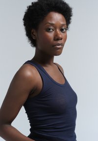 Top in cotone blu navy con scollatura a oblò e design aderente, caratterizzato da una texture liscia e privo di motivi o accessori visibili.