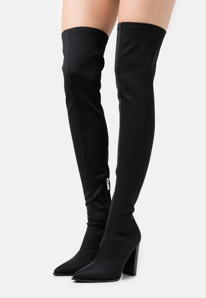 Bottes noires au-dessus du genou en tissu lisse avec un bout pointu et un talon bloc ; dotées d'une fermeture éclair latérale pour un enfilage facile.