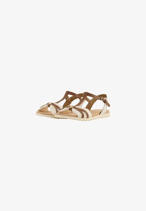 Sandalias de tiras marrones y crema con suela plana, que presentan tiras cruzadas y un acabado texturizado, acentuadas por un pequeño detalle metálico.