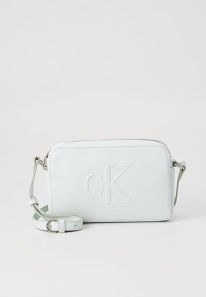 White rectangular crossbody bag with adjustable strap, embossed "cK" logo on front, and silver hardware, set against a plain background.