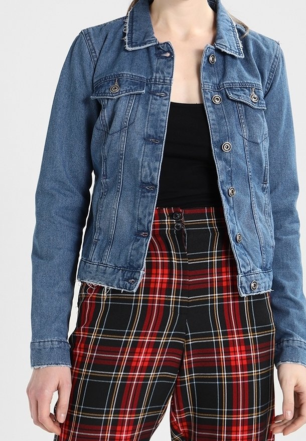 Denimjacka med en skräddarsydd design, blå färg, knappstängningar, två bröstfickor och fransad nederkant. Matchad med röd och svart rutiga byxor.