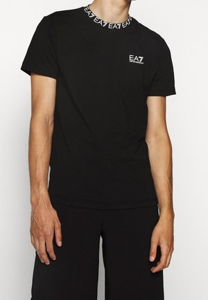 Schwarzes Baumwoll-T-Shirt mit kurzen Ärmeln. Verfügt über einen runden Ausschnitt mit einem weißen EA7-Logo-Band und einem kleinen weißen Logo auf der linken Brust.