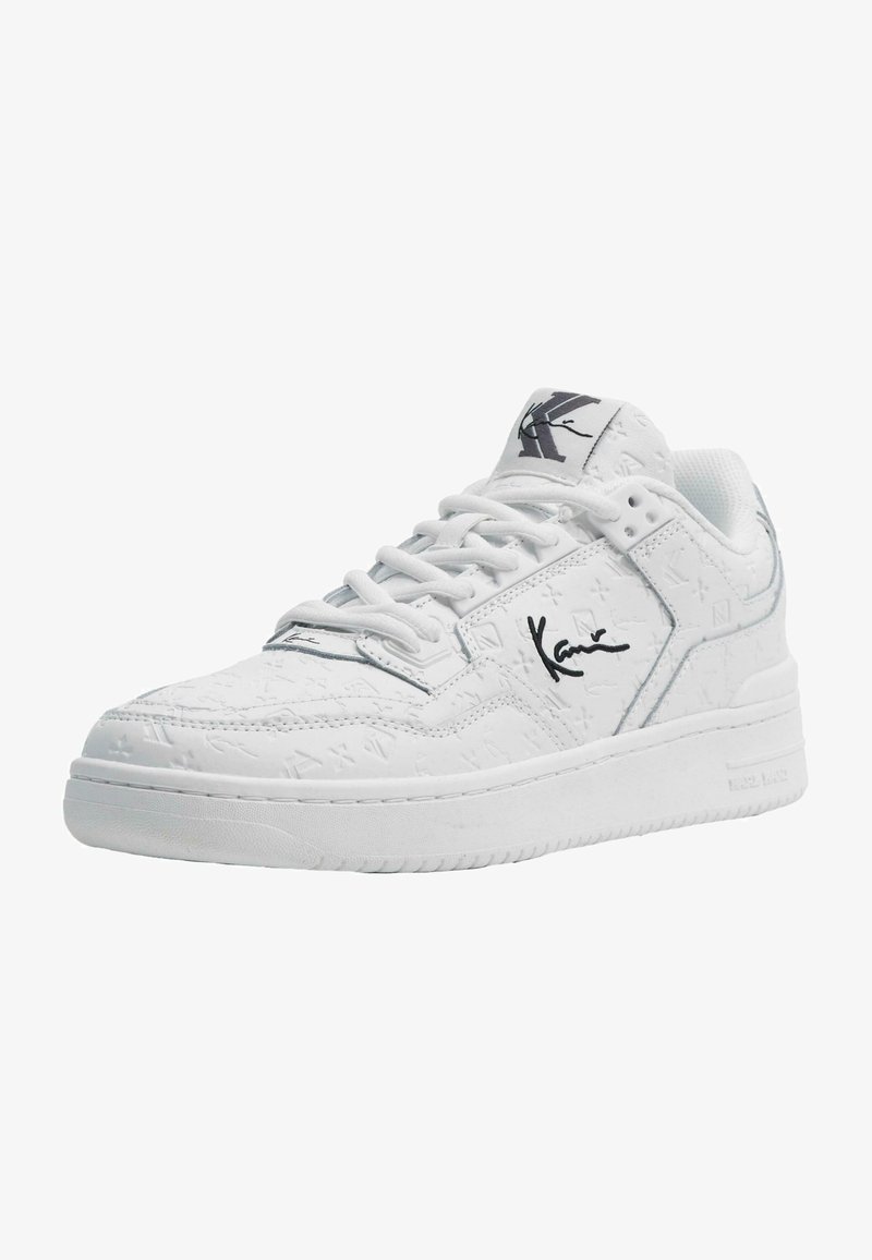 Valged tossud tekstureeritud pinnaga, millel on muster. Kujunduses on must allkiri ja hall logo keelel.