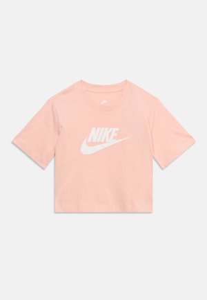 Ροζ ανοιχτό ροζ κοντομάνικη τοπ με λευκό λογότυπο Nike και το σημάδι swoosh στο κέντρο μπροστά, στρογγυλή λαιμόκοψη, σε απλό λευκό φόντο.