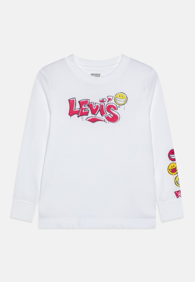 Camisa blanca de manga larga con el logo rojo de Levi's y un emoji sonriente usando una máscara impreso en el pecho, y diseños de emojis coloridos en la manga.