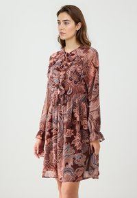 Langärmliges Kleid mit einem Paisleymuster in Braun-, Rosa- und Blautönen. Rüschendetails und eine geraffte Taille sorgen für Textur.